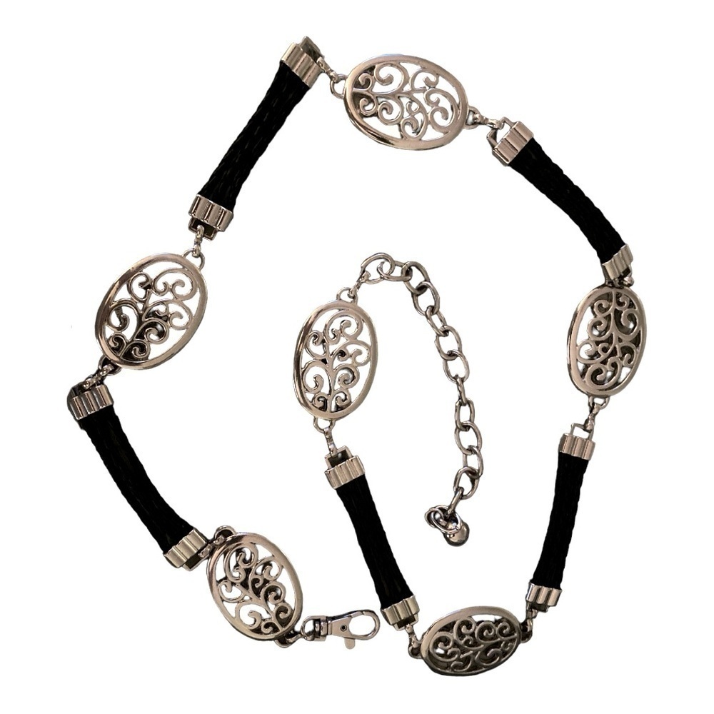 Belt, silver oval medallions connected with black leather cords.